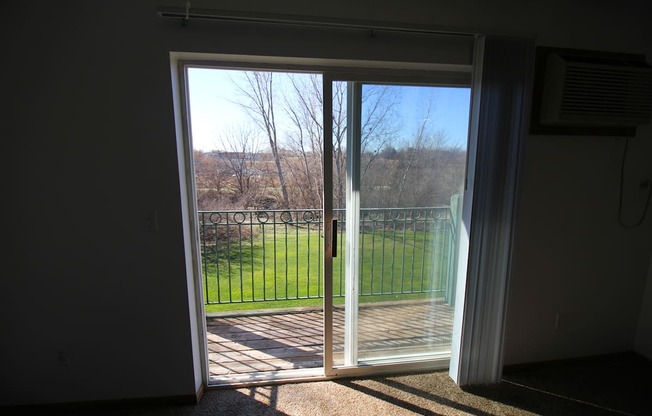 a bedroom with a sliding glass door leading to a balcony