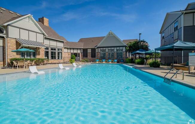 A large swimming pool in front of a house.