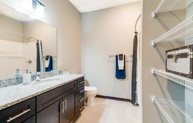 A bathroom with a marble countertop and a walk-in shower.