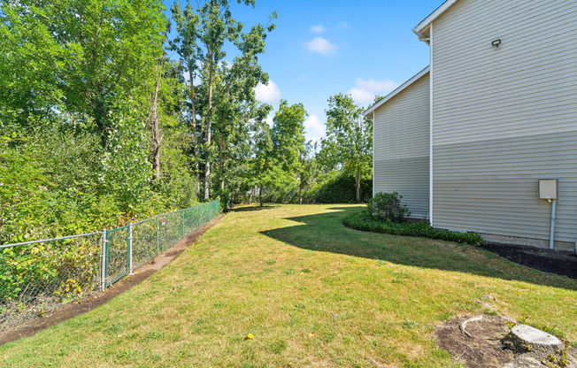 a backyard with a fence and a house