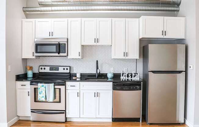 A kitchen with white cabinets and stainless steel appliances.