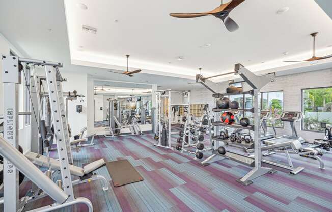 a gym with weights and a ceiling fan