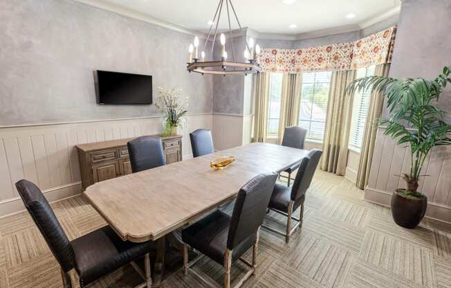 a dining room with a wooden table and chairs and a television