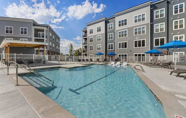 A swimming pool in front of apartment buildings.