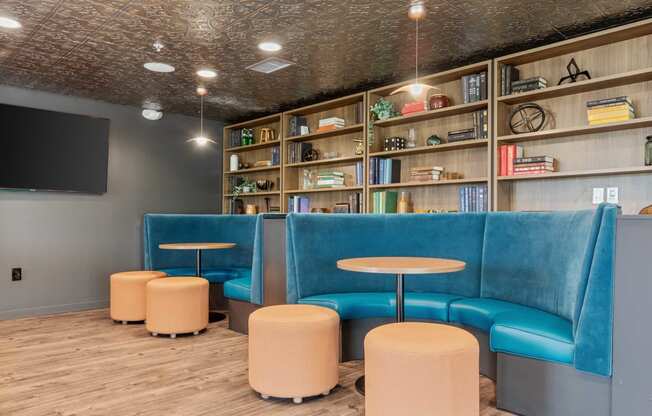 a lobby with blue chairs and tables and a tv