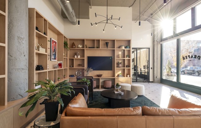 a living room with leather furniture and a large window at The Draper, Missouri, 63103