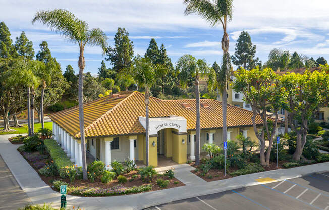A building with a yellow sign that says "Community Center" is surrounded by trees.