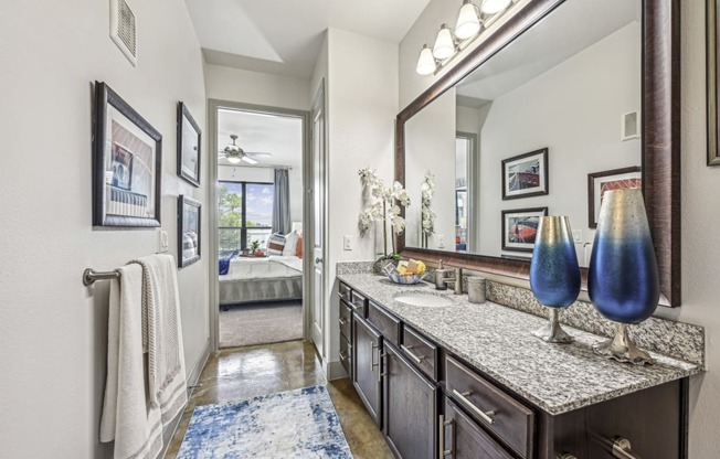 Elegant bathroom with granite countertops and modern fixtures at Allusion at West University apartments in Houston, TX