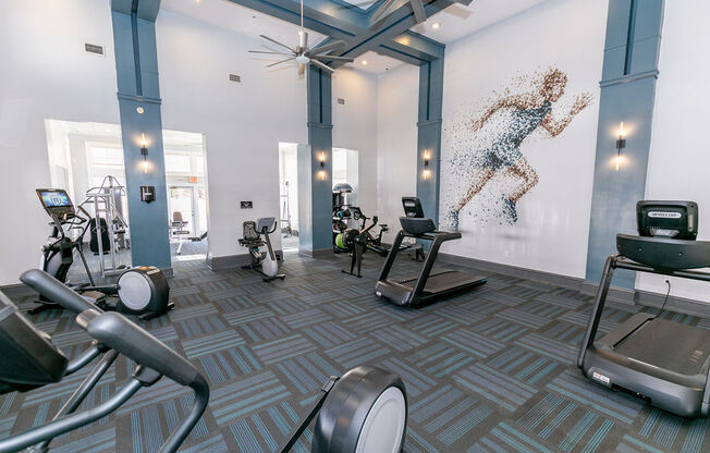 a workout room with weights and a mural of a woman on the wall at Roswell Village, Roswell, GA, 30075