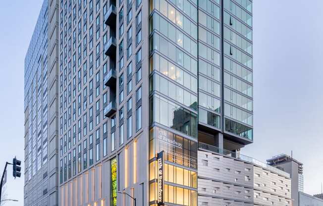 A tall building with many windows is lit up with yellow lights.