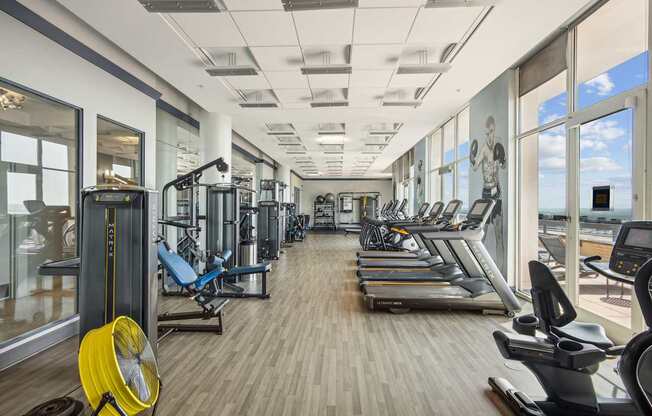 A gym with a variety of equipment including treadmills, weights, and exercise machines.