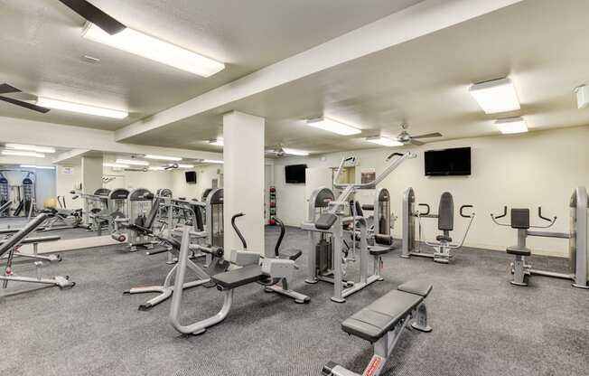 The Retreat's Fitness center with multiple weight systems & cardio equipment.  Large room that is well-lit and with ceiling fans.