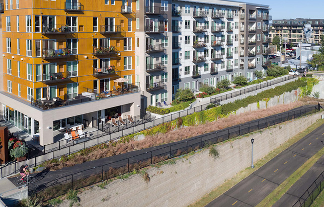 A yellow building with balconies is on the left and a white building with balconies is on the right.