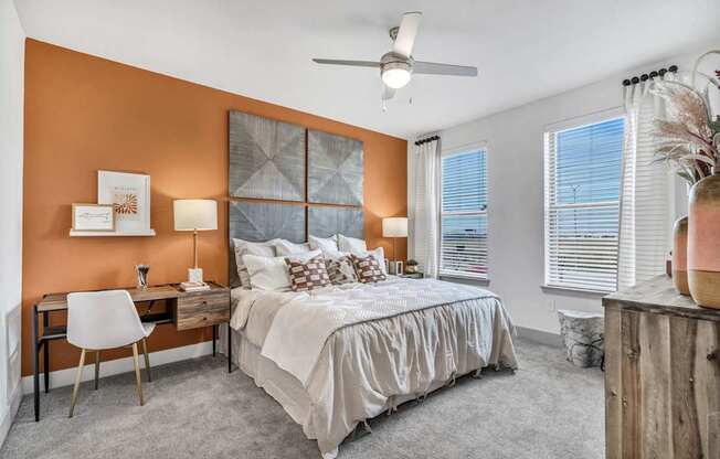 A bedroom with a bed, desk, and chair.