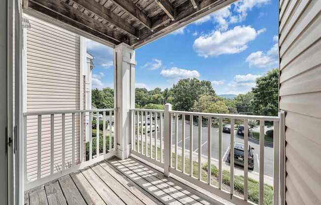 A balcony with a white railing and a view of the street below.