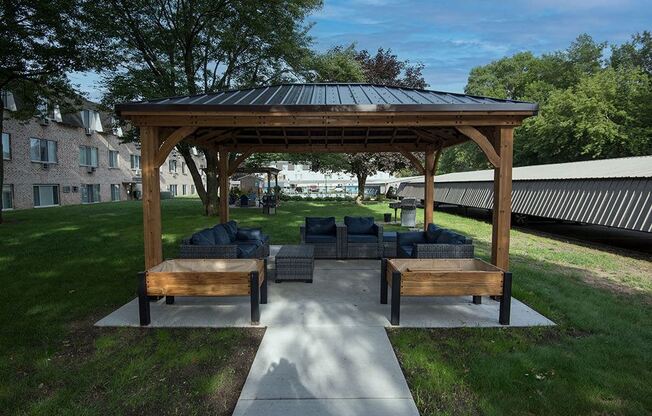 a pavilion with a couch and tables on a patio