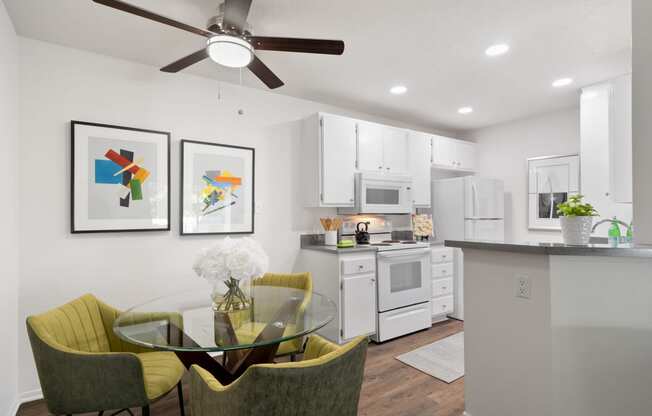 an open kitchen and dining area with a glass table and chairs