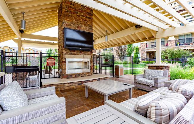 A patio with a fireplace and seating area.