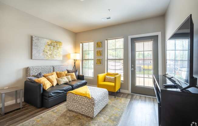 a living room with a couch and a chair and a tv