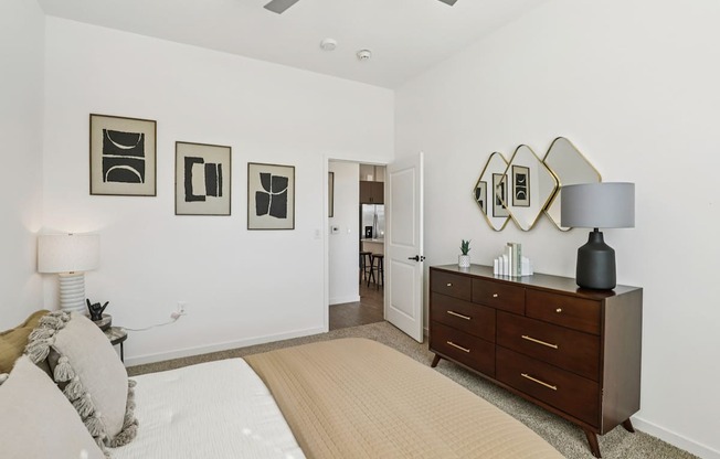 A bedroom with a bed, dresser, and mirror.