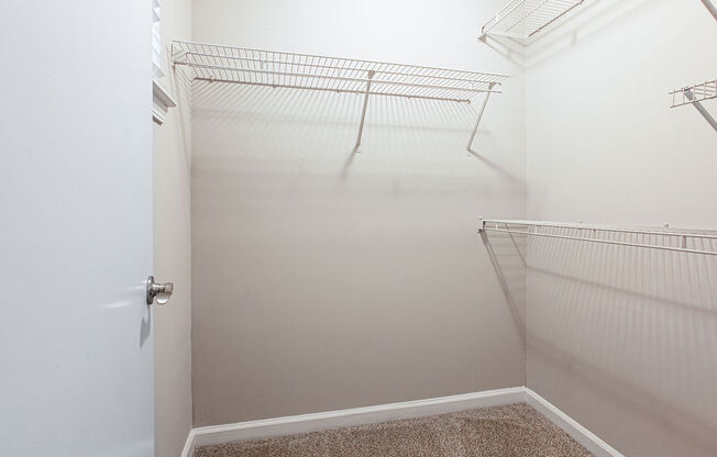 an empty walk in closet in a bathroom with a white door