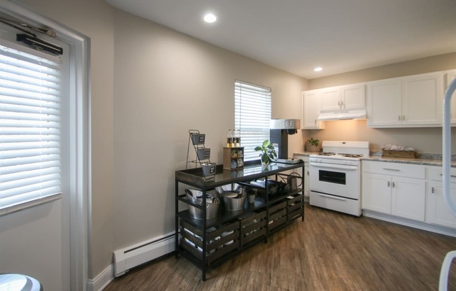 a kitchen with white appliances and a black counter top