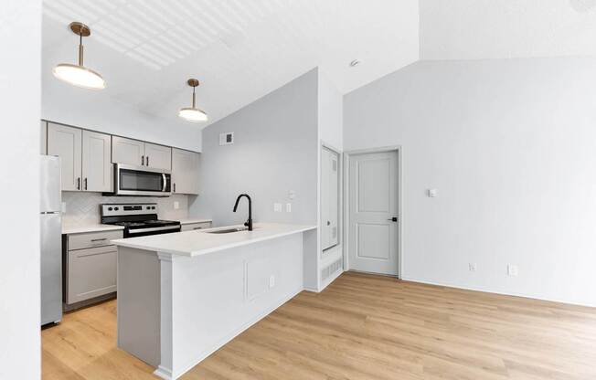 A kitchen with a white counter top and a stove top oven.