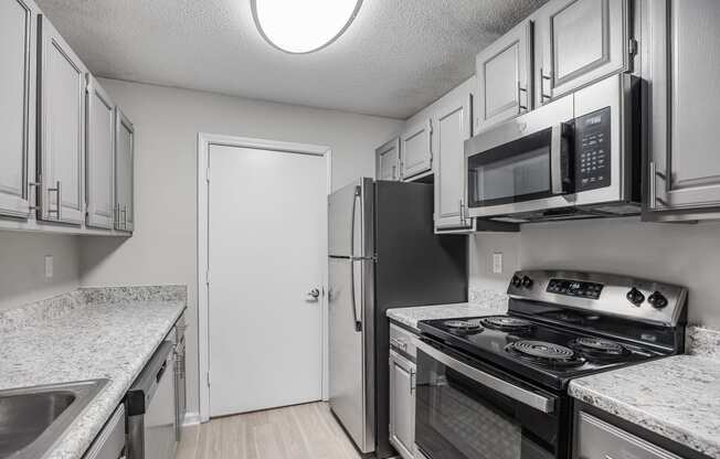 a kitchen with stainless steel appliances and white cabinets