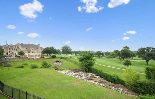 a view of a golf course with a house in the background