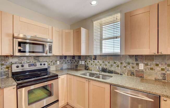 A kitchen with wooden cabinets and a tiled backsplash.