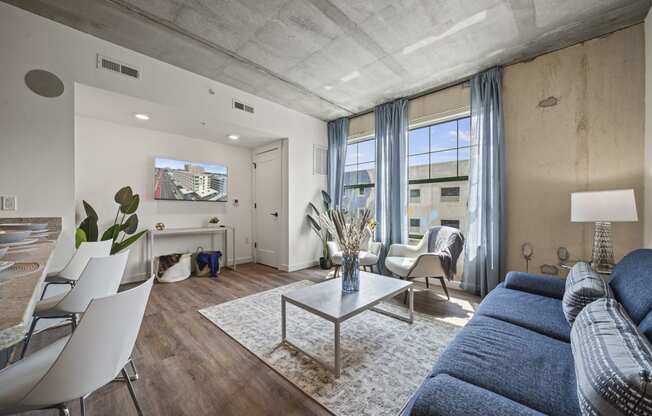 a living room with a blue couch and a white coffee table  at The Icon, Virginia, 23230