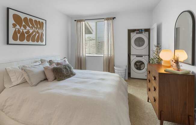 a bedroom with a bed and a washer and dryer