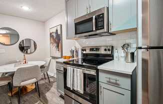 A modern kitchen with a stove top oven and microwave.