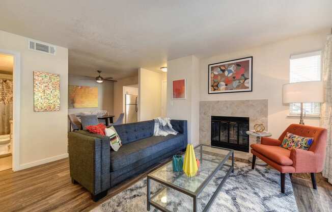 Living Room with Dining Area with Wood Inspired Floors,  Orange Chair, Hardwood Inspired Floor, Gray Sofa, Black/White Rug 