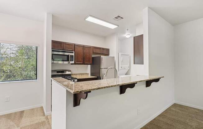 A kitchen with white walls and brown cabinets.