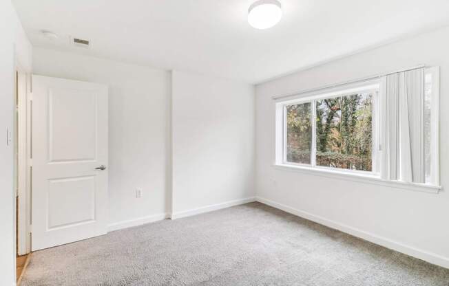 an empty room with a window and a door