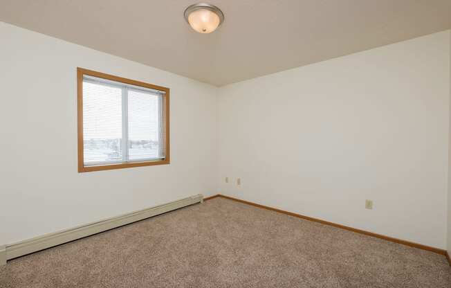 A bedroom with a window and a carpeted floorFargo, ND Park Circle Apartments | Kitchen