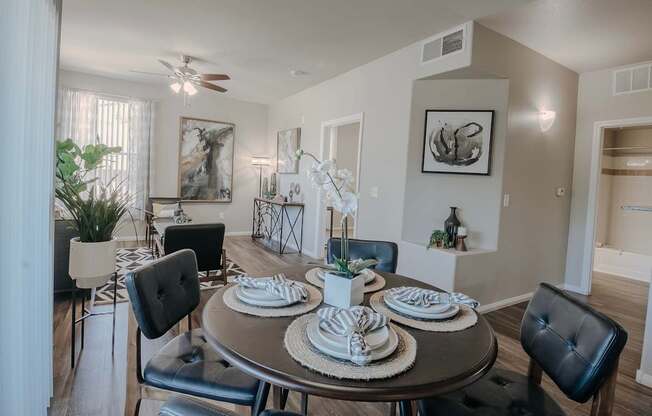 A dining room with a round table set for four.