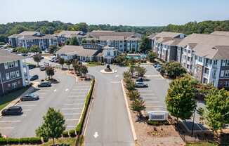 an aerial view of an apartment complex with cars in a parking lot