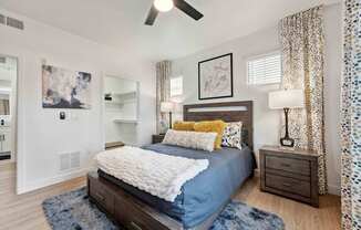 A bedroom with a bed, nightstand, and a ceiling fan. at The Laurel Apartments, Chandler, AZ 85286