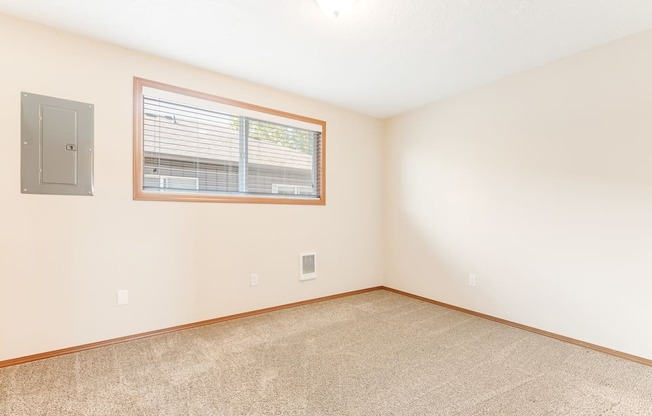 a bedroom with white walls and a large window