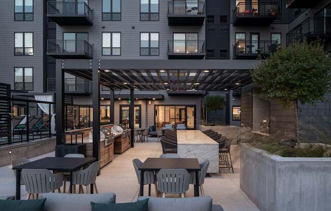 A modern outdoor patio area with a table and chairs.
