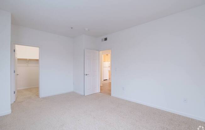 A large, empty room with white walls and carpeted floor at Cornerstone at Gale Ranch Apartments, San Ramon