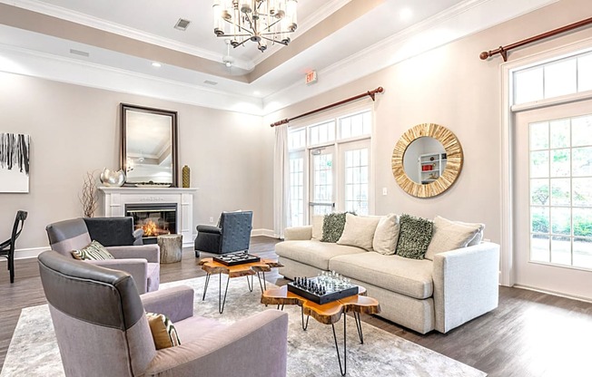 A living room with a fireplace, couch, and chairs.