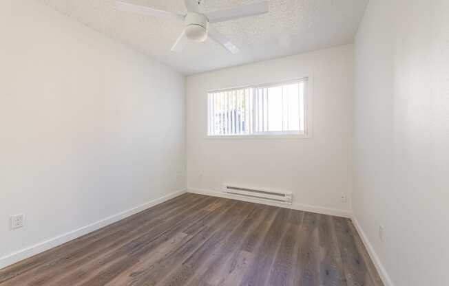 a bedroom with hardwood floors and a ceiling fan