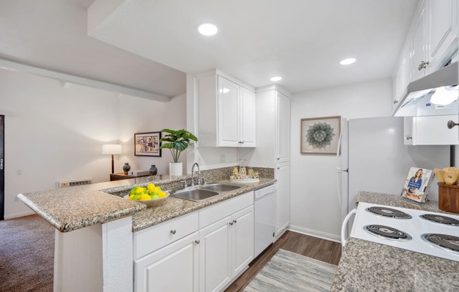 a kitchen with white cabinets and granite countertops