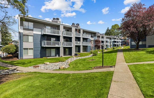 Apartment complex with a walkway in front.