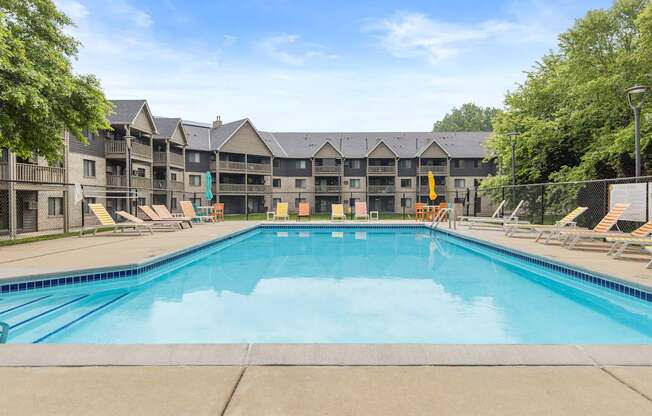 A large swimming pool in front of apartment buildings.