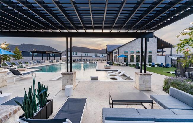 A covered poolside lounge at Amavi Celina with shaded seating, open views, and inviting spaces to relax or gather throughout the day.