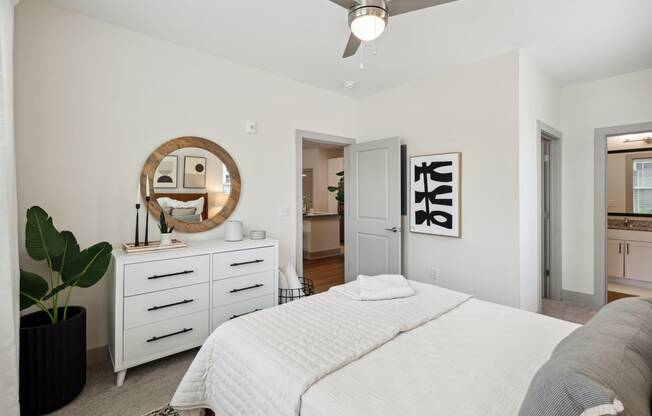 a white bedroom with a white bed and a ceiling fan